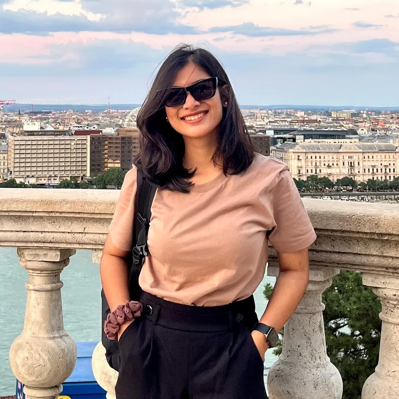 Sadia standing on a balcony overlooking a city